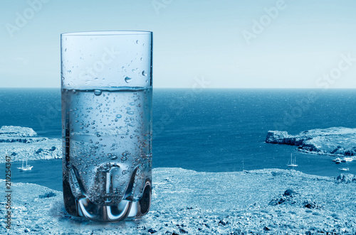 Cuadros en Lienzo Glass of sparkling pure water against the sea background