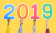 © Rawpixel.com - Hands holding 2019 on yellow background