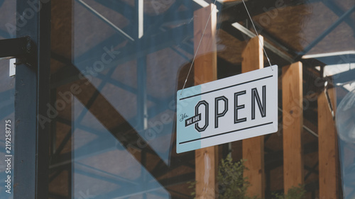 Cuadros en Lienzo CU we are open sign hanging on the entrance door of a small cafe