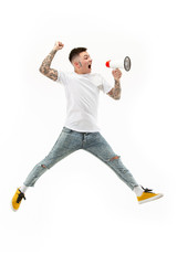 Jumping fan on white background. The young man as soccer football fan with megaphone