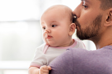 Canvas Print - family, parenthood and people concept - close up of father kissing little baby daughter