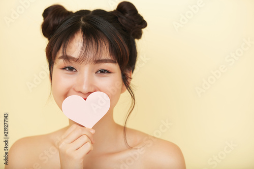 Adorable Young Asian Woman With Stylish Hair Buns Holding Paper