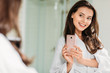 © LIGHTFIELD STUDIOS - smiling young woman in bathrobe taking selfie with smartphone at mirror in bathroom