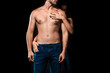 © LIGHTFIELD STUDIOS - partial view of woman hugging shirtless boyfriend in jeans isolated on black