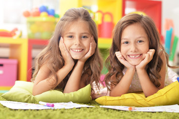 Portrait of two beautiful little girls studying