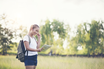 Young woman tourist holding map on trip