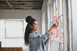 © ReeldealHD images - Young adult female brainstorming in a creative office with adhesive notes