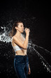 © LIGHTFIELD STUDIOS - side view of woman swilled with water while drinking water from glass isolated on black