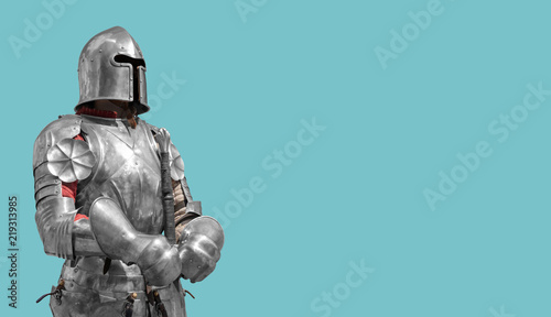 Fotografía Medieval knight in shiny metal armor on a blue background.