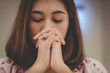 © wirat - Women praying to the holy scripture. Her pray hands Bible in church for the faith and spiritual christian concept of religion.