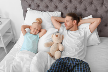 cute little girl with her father in bed. sleeping time