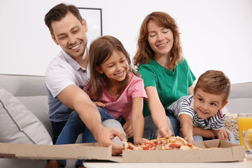 Wall Mural - Family eating pizza while watching TV in room