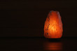 Himalayan salt lamp glowing on dark background with space for text