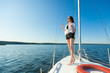 © Smeilov - Girl standing on the bow of a sailboat, boat. Copy space