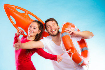 Happy lifeguard couple with equipment