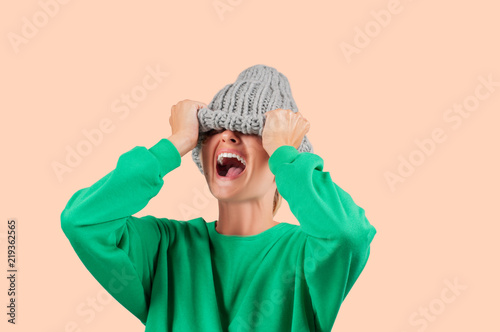 Fotografie, Obraz Crying emotional angry woman is pulling wool hat over her eyes