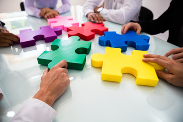 Wall Mural - Group Of Businesspeople Solving Jigsaw Puzzle