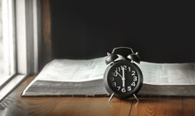 Alarm Clock With Holy Bible On Wooden Table. Christian Concept.