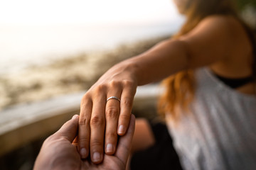 Wall Mural - man holding females hand with engagement ring on it after wedding proposal