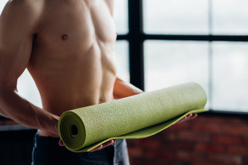 Wall Mural - sport fitness and gym training. taking care of your body health. man holding yoga mat prepared to exercise.