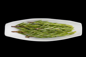 Rosemary green fresh twigs in a bowl. Top view. Closeup. Isolated on black, element for your design.