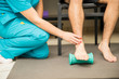 © AntonioDiaz - Therapist Assisting Patient To Use Foot Roller For Plantar Fasciitis