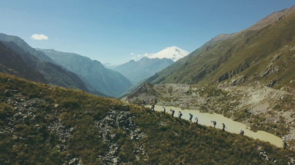 Wall Mural - view from above hiking group walking on mountain trail. climbing a mountain