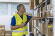 © Dragana Gordic - Warehouse worker holding clipboard in a large warehouse