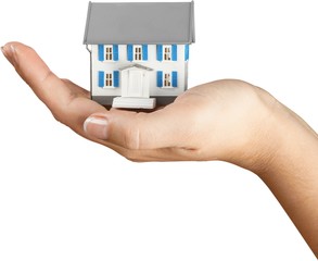 Poster - Classic house model in human hand isolated on white background