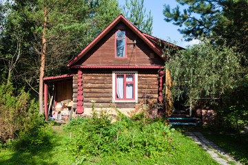 Canvas Print - wooden country house in green garden on summer day