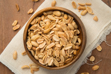 Roasted Peanuts In Wooden Bowl Putting On Linen And Wooden Background.