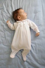 Wall Mural - Newborn baby girl sleeping on blue sheets