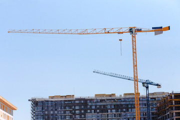 Crane lift is a large crane. Used for lifting equipment in the construction of high-rise buildings behind the sky, behind modern building with concrete columns and floors on a construction site