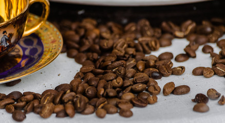 Roasted coffee beans with a classic porcelain cup