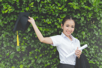 Beautiful Attractive Asian Women Student Graduate in cap and gown celebrating with certificate in her hand and feeling so proud and happiness in Commencement day,Education Success Concept