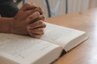 © 88studio - hand praying on opening holy bible. faith, religion concept