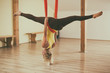 Woman doing aerial yoga in the fitness studio.
