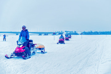 Wall Mural - People on Snowmobiles in Winter Finland Lapland during Christmas