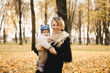 © ksyusha_yanovich - Portrait of a young mother with her baby in the autumn Park.