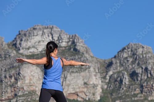 Fotografie, Obraz Active Young Woman Doing Yoga with Mountains in Background