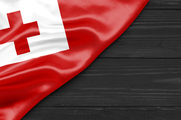 Wall Mural - Flag of Tonga and place for text on a dark wooden background