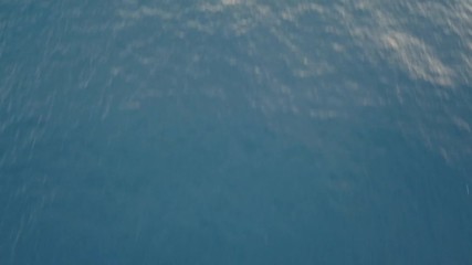 Wall Mural - moving forward over blue ocean water, camera tilting up discovering beautiful landscape with volcano