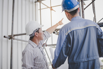 Construction engineers talk to architects at construction sites or buildings.They makeing are construction projects together as a team.