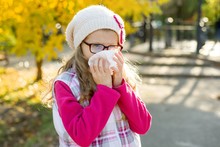 Girl Child With Cold Rhinitis On Autumn Background, Flu Season, Allergy Runny Nose