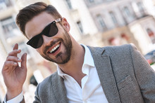 Portrait Of A Young Handsome Man, Model Of Fashion, Wearing Tinted Sunglasses In Urban Background