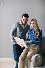 Man and a woman with a laptop smiling