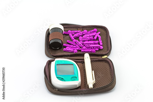 Fotografía blood glucose meter, the blood sugar value is measured on a finger pack in black case on white background