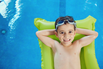 Wall Mural - Little boy smiling child smiling at swimming pool indoors.