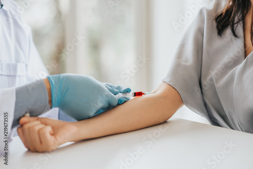 Cuadros en Lienzo Doctor using syringe takes blood from patient arm