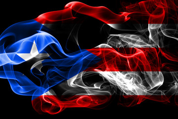 Wall Mural - National flag of Puerto Rico made from colored smoke isolated on black background. Abstract silky wave background.
